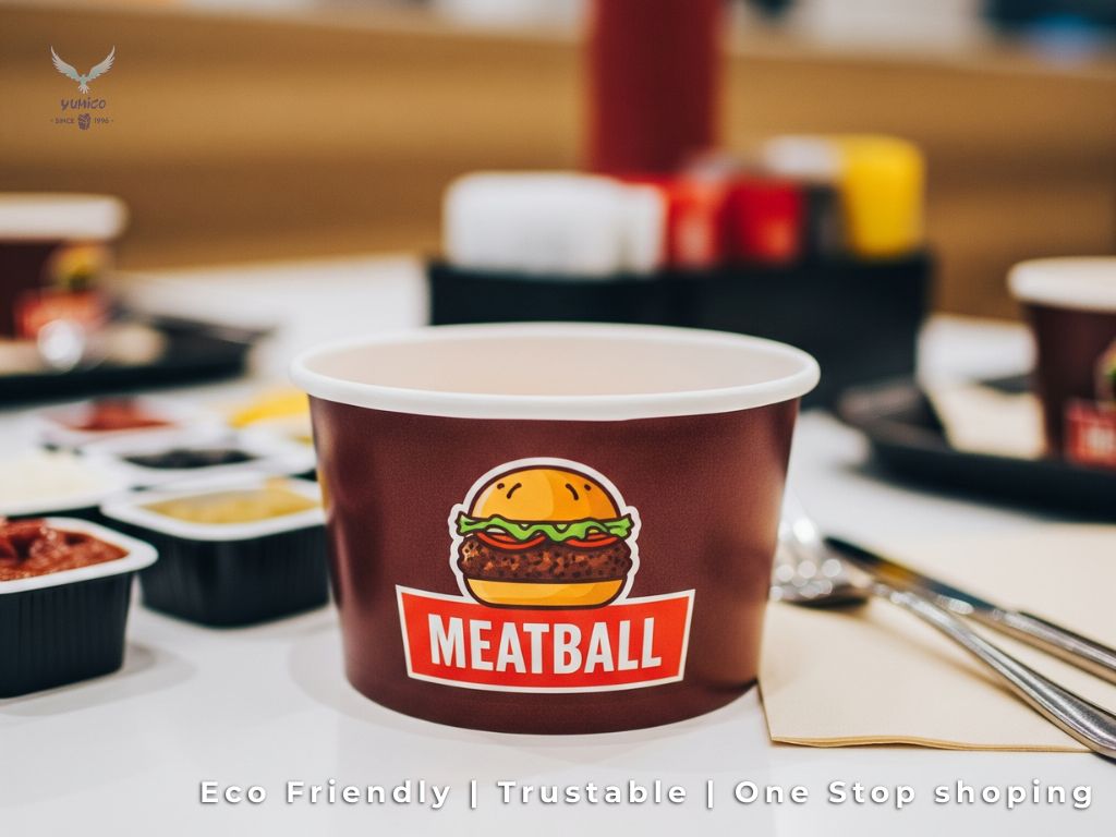 Paper Bowl Bakso Kualitas Premium untuk Bisnis Kuliner Anda Close up paper bowl putih dengan logo bakso di atas meja restoran cepat saji, menampilkan kualitas produk dari penjual yang jual grosir paper bowl.
